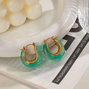 Elegant 18k gold plated U-shaped earrings with translucent green resin on ceramic dish