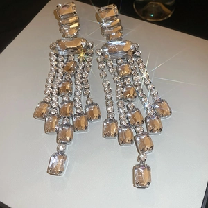 Macro shot of silver tassel earrings with square rhinestones for formal evening wear