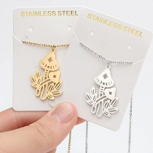 Detail of mushroom pendant necklaces in gold and silver finish on display cards