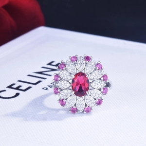 Macro detail of a 2ct oval red sapphire ring with pink floral petals and silver band