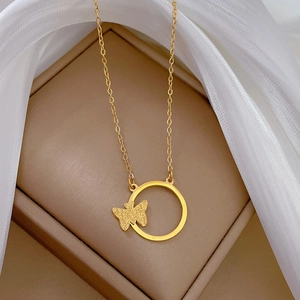 Detail of gold titanium steel ring necklace with a matte butterfly on jewelry box