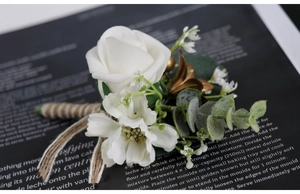Detail of white PE rose boutonniere with eucalyptus leaves and twine wrapped handle