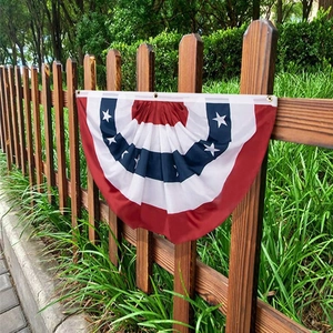 US Independence Day pleated fan flag with stars and stripes hanging on a wooden fence
