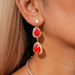 Gros plan sur l'ensemble boucles d'oreilles et collier goutte rouge avec finition dorée
