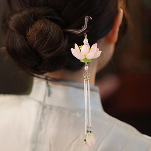 Dettaglio di forcina per capelli in legno di loto con nappe di perle in un elegante chignon