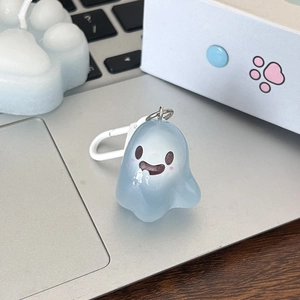 Detail of light blue translucent jelly ghost keychain on a desk with a white clip