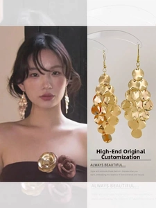 Close-up of golden layered disc tassel earrings and view of woman wearing the jewelry