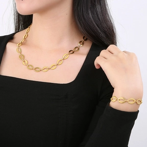 Chic gold stainless steel oval link chain necklace and bracelet set shown on a model