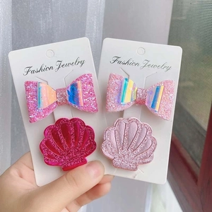 Close-up of pink glitter bow and shell hair clips for girls on display cards