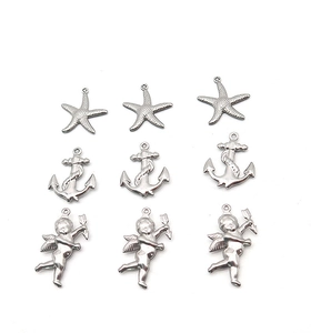 Detailed macro view of silver stainless steel starfish, anchor and angel DIY charms