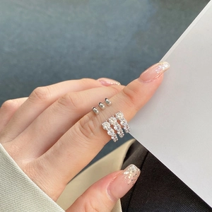 Detail of multi-layered silver ring with pave-set zircons on a model's finger