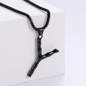 Détail macro du collier avec pendentif Y en forme de branche noire sur cube blanc