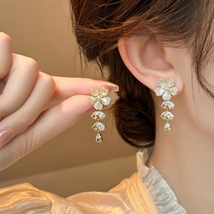 Elegant gold floral drop earrings with white petals and shimmering crystal waterdrops