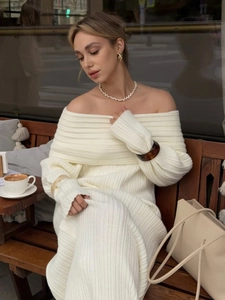 Close-up of cream-white off-shoulder knitted dress with ribbed texture on a model