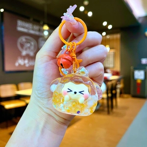 Detail of cartoon dog liquid quicksand keychain with orange ring and red bell