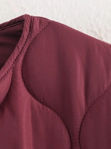 Detail of burgundy quilted jacket neckline and shoulder with premium stitching work
