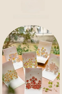 Detail of 3D pop-up floral greeting cards with colorful paper flowers on wooden desk
