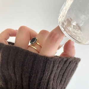 Detailed view of a gold double-layer silver ring featuring an oval black zircon stone