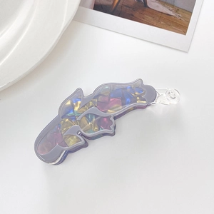 Detail shot of a purple acrylic banana hair clip with iridescent geometric patterns