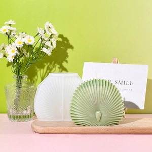 Dettaglio dello stampo in silicone a conchiglia 3D e candela verde su vassoio