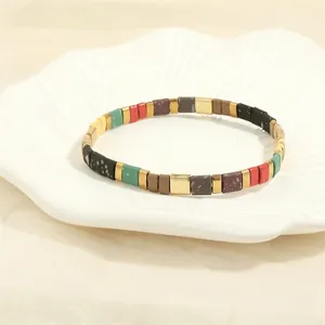 Detail of colorful Tila bead stretch bracelets in bohemian style on shell dish