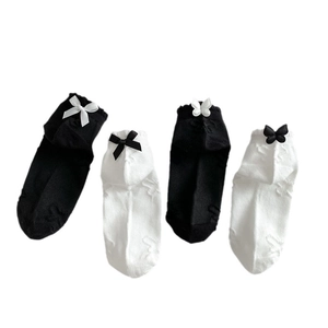 Lace-trimmed cotton boat socks in black and white with contrast bow accents