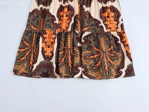Close-up detail of ethnic print fabric in orange and brown for vacation maxi dress