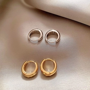 Polished teardrop hoop earrings in gold and silver finish on elegant silk background