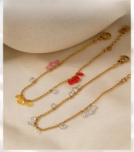 Detail view of gold beaded bracelets with colorful zircon water drop charms and lobster clasp