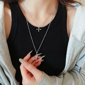 Double-layered silver cross necklace with lava-style pendant for women on model