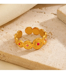 Macro view of 18K gold plated ring featuring pink enamel discs on a stone surface