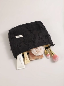 Minimalist black linen cotton makeup bag with textured surface and ample internal storage