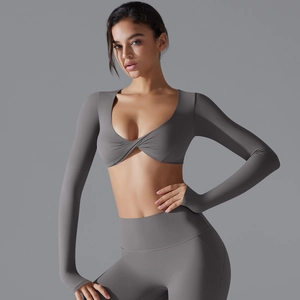 Dettaglio del top da yoga grigio a maniche lunghe con nodo e leggings a vita alta