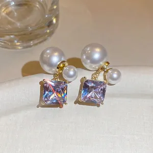 18k gold plated earrings featuring square purple zircon and pearls on fabric