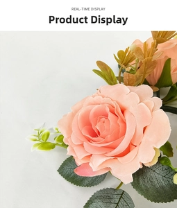 Close-up of peach pink faux roses with realistic petals and green leaves for decoration