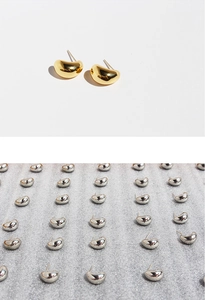 Macro detail of polished bean-shaped stud earrings in gold and silver finishes