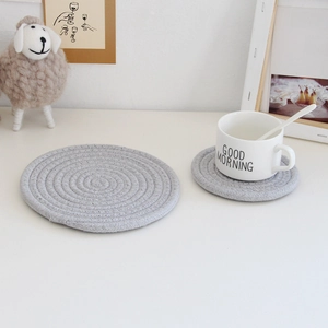 Macro detail of two grey woven cotton rope placemats on a bright white table setting