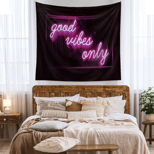 Detail of black bohemian tapestry with neon pink Good Vibes Only text in cozy bedroom