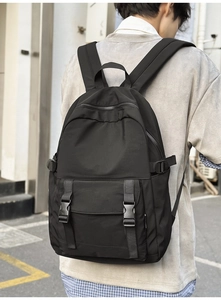 Vista trasera de un modelo con mochila de negocios negra impermeable y cierre de hebilla