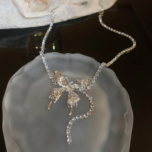 Macro view of butterfly pendant on silver mesh chain with shimmering crystal details