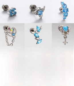 Macro detail of six titanium steel piercing studs with blue zircons and chain accents