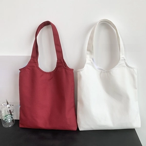 Detail of minimalist red and white canvas tote bags with wide shoulder straps
