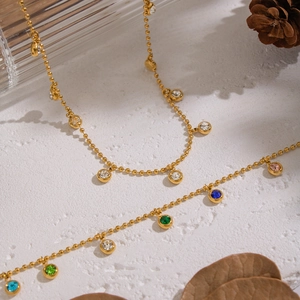 Golden double-layer bead chain necklace with colorful zircon pendants on white surface