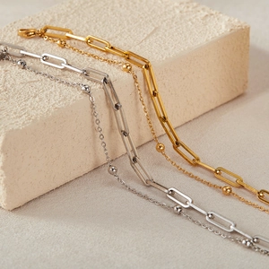 Detail of gold and silver stainless steel paperclip chain bracelets with small beads