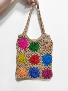 Detail of handmade crochet tote bag featuring colorful floral granny square patterns
