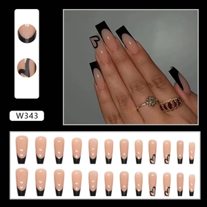 Detailed view of long coffin press-on nails with black French tips and heart pattern