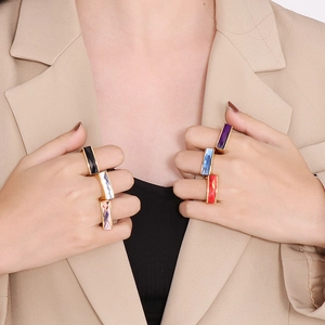 Close-up of rectangular luxury glass gemstone rings in multiple colors on fingers