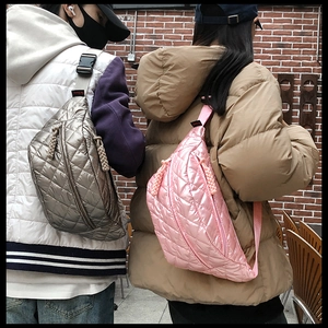 Rear view of couple wearing quilted crossbody waist bags in silver and pink colors