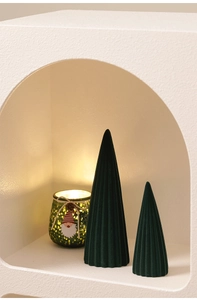 Close-up of green ceramic Christmas trees and glowing Santa glass jar in alcove