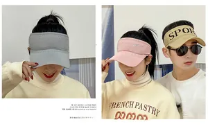 Detail of three knitted sport sun visors in grey, pink and beige with SPORT embroidery
